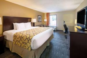 a hotel room with a large bed and a flat screen tv at Baymont by Wyndham Columbus GA in Columbus