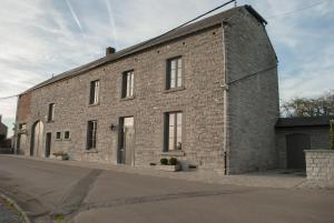 a large brick building with windows on a street at Chez Peponne in Dinant