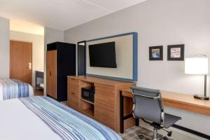 a hotel room with a bed and a desk with a television at AmericInn by Wyndham Branson & Conference Center in Branson