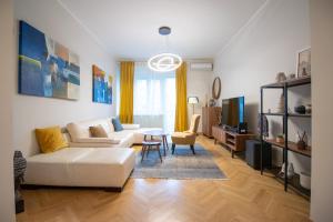 Una sala de estar con un sofá blanco y una mesa. en Dani City Center Apartment, en Belgrado