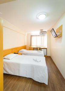 a hotel room with two beds and a tv at Condall Palace Hotel in Nova Prata