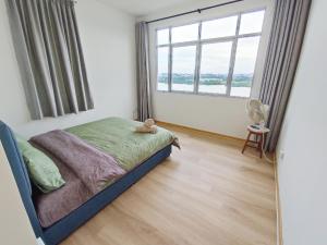 a bedroom with a bed and a large window at Muji homestay kuching scenic view 2 bedrooms entire apartment in Kuching