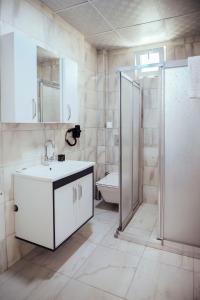 La salle de bains est pourvue d'une douche, d'un lavabo et de toilettes. dans l'établissement GRAND ÇAKIROĞLU HOTEL, à Aksaray