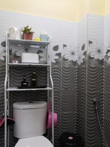 a bathroom with a toilet and flowers on the wall at Darney's Homestay Kg Bangau Tanjung in Temerloh