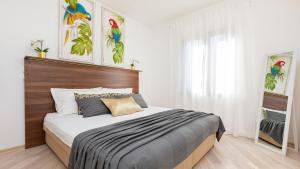 1 dormitorio con 1 cama con cabecero de madera en Palm Apartments with Swimming pool, en Mlini
