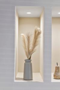 a grey vase with feathers in it in a shelf at The Burlington by STAMP SA in Blackpool