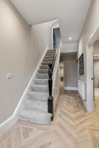 - un escalier dans une maison dotée de murs blancs et de parquet dans l'établissement The Burlington by STAMP SA, à Blackpool
