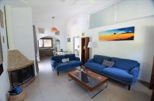 een woonkamer met twee blauwe banken en een open haard bij Bay Cottage Beautiful cosy luxury cottage - Beach area in Pissouri