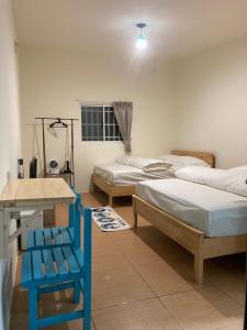 Habitación con 2 camas y silla azul en 老老街 誠君民宿 en Fenchihu