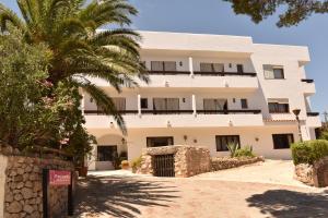 a building with a palm tree in front of it at Hostal Marblau Ibiza in Ibiza Town