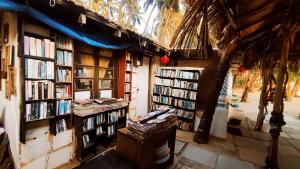 una librería con muchos libros en las paredes en Cozy Nook Goa Palolem, en Palolem