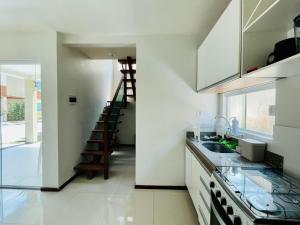 a kitchen with white cabinets and a staircase in the background at Casas em barrerinhas lencois ville in Barreirinhas