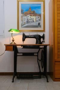 una vecchia macchina da cucire seduta su una scrivania con lampada di La casa di zia Imma nel dirupo a Pisticci