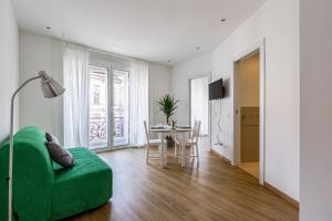 a living room with a green couch and a table at Top Accommodations in the Heart of Milano! in Milan