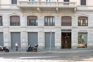 Top Accommodations in the Heart of Milano! في ميلانو: اثنين من الدراجات النارية متوقفة أمام المبنى