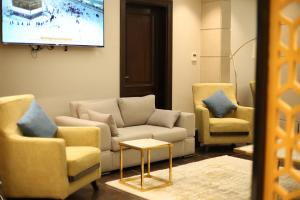a living room with a couch and two chairs at Rahhal Hotel Suites in Yanbu