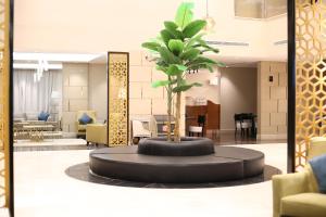 a palm tree in a circle in the middle of a lobby at Rahhal Hotel Suites in Yanbu