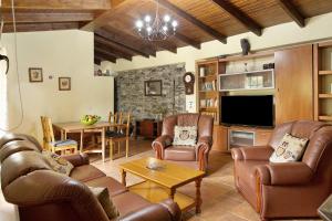 a living room with leather furniture and a television at Casa Irene in Teror