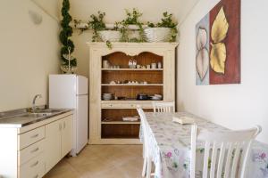eine Küche mit einem Tisch mit Stühlen und einem Kühlschrank in der Unterkunft Appartamento 2 - Palazzo Costantini in San Donato di Lecce
