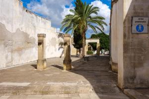 eine Straße mit einer Palme neben einem Gebäude in der Unterkunft Appartamento 2 - Palazzo Costantini in San Donato di Lecce