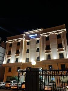a building with a lit up sign in front of it at Rahhal Hotel Suites in Yanbu