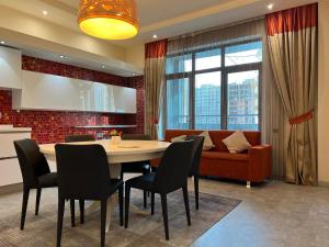 a dining room with a table and chairs and a couch at Megafun Luxury Family Apartment in Baku