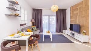 sala de estar con mesa blanca y TV en Palm Apartments with Swimming pool, en Mlini