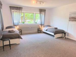 a bedroom with two beds and a window at Holiday Apartments Brachttal in Hellstein