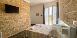 a room with a table and a tv on a brick wall at Residenza Case Arse in Torre Lapillo