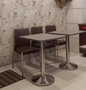 a table and chairs in a room with a wall at HOTEL PRATIKSHA RESIDENCY in Navi Mumbai