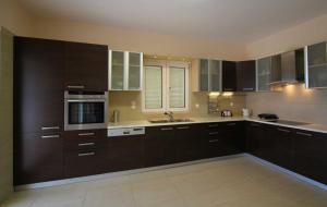 a large kitchen with brown cabinets and appliances at Luxury Zante Villa Zante Vista Villa Private Pool Seaviews Agios Sostis in Laganas