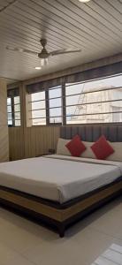 a bedroom with a large bed with red pillows at HOTEL PRATIKSHA RESIDENCY in Navi Mumbai