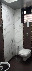 a bathroom with a toilet and a shower at HOTEL PRATIKSHA RESIDENCY in Navi Mumbai