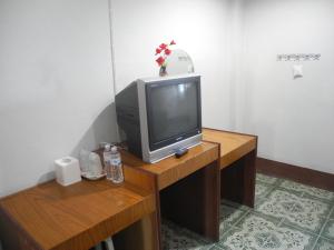 a television sitting on top of a wooden table at Nam Pueng Place 1 in Chiang Saen