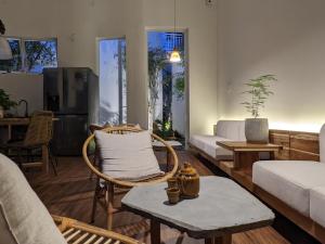 a living room with a chair and a couch at Metta Homestay Hue in Hue