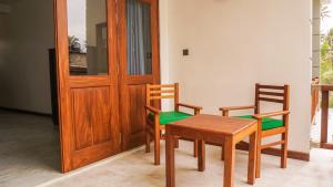 een tafel en twee stoelen en een houten deur bij The Green Rooms Surf & Yoga Camp - ON THE BEACH - Prime location Weligama Bay in Weligama