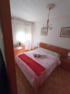 a bedroom with a large bed with a red blanket at Apartamento Merlin in Roquetas de Mar