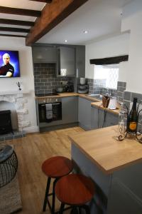 a kitchen with a counter and two stools in it at Daisy Cottage in Wakefield