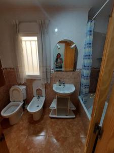 y baño con lavabo, aseo y espejo. en Apartamento Merlin, en Roquetas de Mar