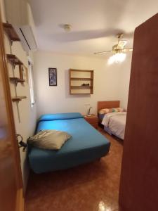 a bedroom with a blue bed in a room at Apartamento Merlin in Roquetas de Mar