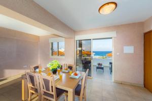 uma sala de jantar com uma mesa e vista para o oceano em Pelagos apartment 6 em Paralimni