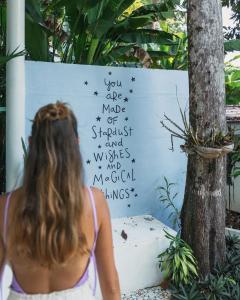 a woman standing next to a sign with writing on it at Indie Beach Bungalows in Ko Chang