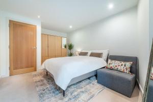 1 dormitorio con 1 cama grande y 1 silla en Cosy apartment 15 minutes from Oxford Circus/Soho, en Londres