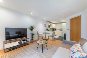 - un salon avec un canapé et une table dans l'établissement Cosy apartment 15 minutes from Oxford Circus/Soho, à Londres