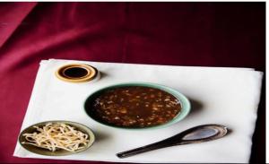 a white napkin with a bowl of chili and spaghetti at Sheldon Inn Kolkata in Kolkata