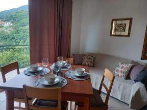 a dining room with a table and chairs and a couch at G&B Apartments in Tignale