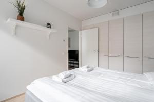 a white bedroom with a white bed and a mirror at 2ndhomes Tampere "Posteljooni" Apt - New 1BR Apt with Balcony and Best Location in Tampere