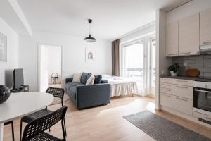eine Küche und ein Wohnzimmer mit einem Sofa und einem Tisch in der Unterkunft 2ndhomes Tampere "Posteljooni" Apt - New 1BR Apt with Balcony and Best Location in Tampere