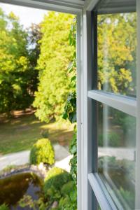 a window with a view of a garden at Gutshauszimmer Neu Gaarz in Neu Gaarz