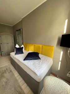 um quarto com uma cama com almofadas azuis e uma cadeira em Gutshauszimmer Neu Gaarz em Neu Gaarz